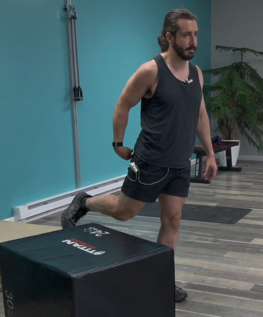 Dr. John with his right leg extended slightly behind him demonstrating how he's squeezing his glute at the end of his rotation for the hip mobility exercise